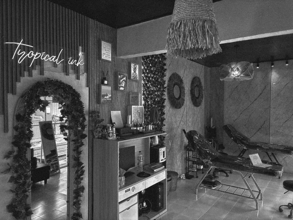 Tropical Ink Bali Canggu studio with neon sign and plant arch