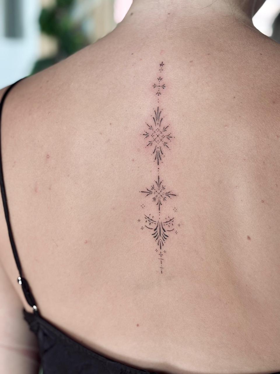 Delicate back spine fine line tattoo in Bali