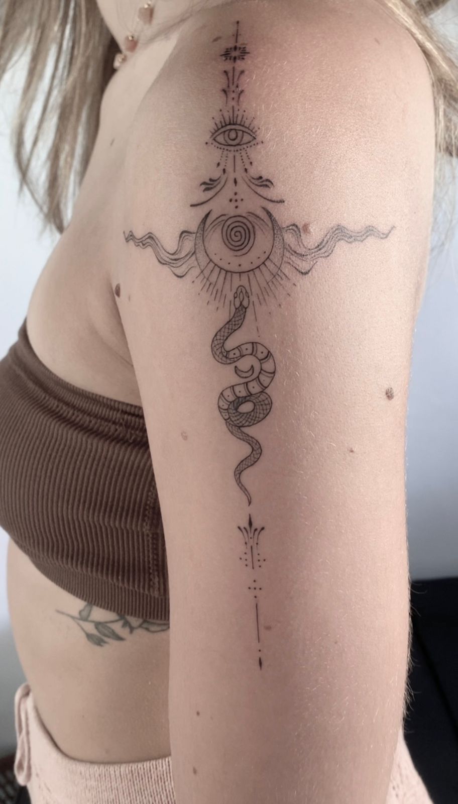 Delicate fine line snake and eye tattoo in Bali
